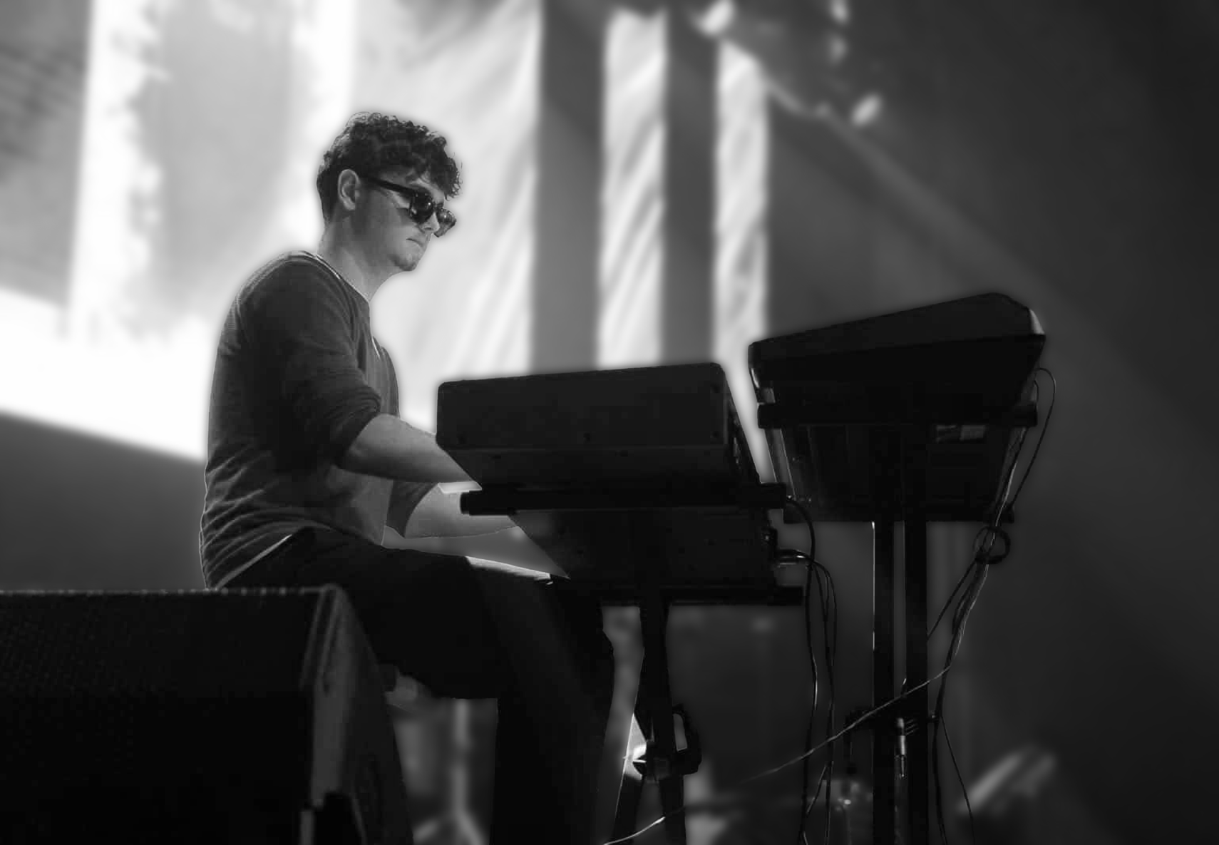 Gal Gros playing at a keyboard under stage light